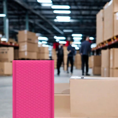 Hot Pink 8.5 X 12 Inch Bubble Mailers Dope Self Seal Padded Envelopes in a warehouse setting with focus on texture and size