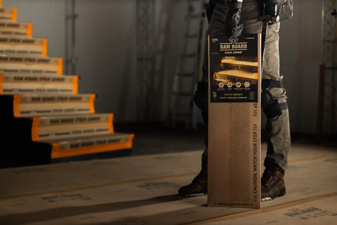 Person holding Stair Armor For Temporary Stair Protection Durable 1.58 Feet By 2.83 Feet 6 Pack with stairs in background.