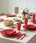 Kickback Ready Red Plastic Dinnerware Set Feeds Fifty Guests With Nine Inch Plates Seven Inch Snack Plates 12 Ounce Cups Utensils And Napkins set on a table.
