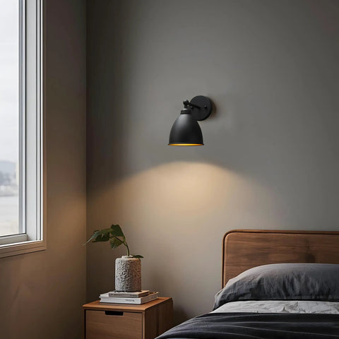Industrial Hardwire Wall Sconce With Old School Farmhouse Vibe in bedroom, black finish, installed above nightstand, soft light