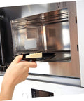 Person placing a plate in a microwave oven, showcasing the mica sheets for microwave oven heat resistant insulation plates 10 pieces.