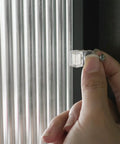 Hand installing a clear glass retainer clip from the Real Deal 25 Pack Glass Retainer Clips With Screws For Cabinets Windows Doors And Mirrors.