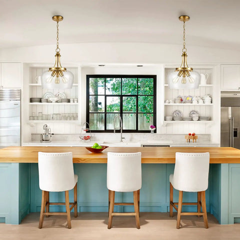 Kitchen with wooden island, white chairs, pendant lights, and window view.