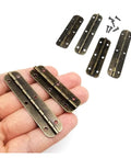 Hand holding 12 Piece Small Piano Hinges Set For Jewelry Boxes And Tiny Furniture, Beefy Iron Build With Screws displayed nearby