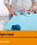 Person using X Large Craft Hole Punch with Ergonomic Easy Squeeze Grip on blue paper for precise clean cuts in scrapbooking
