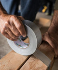 Man using Heavy Duty Silver Duct Tape Roll 1.88 Inch By 45 Yard 1 Pack For Easy Fixes And Household Repairs On Wood Vinyl Plastic Leather Metal