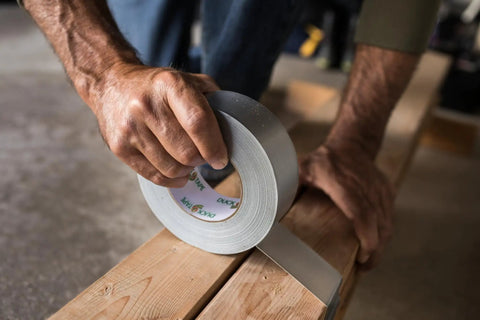 Man using Heavy Duty Silver Duct Tape Roll 1.88 Inch By 45 Yard 1 Pack For Easy Fixes And Household Repairs On Wood Vinyl Plastic Leather Metal