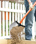 Person using Heavy Duty All Steel Round Point Shovel With 48 Inch Tubular Alloy Handle One Piece Welded Construction Thick 12 Gauge Blade 8.75 By 11.75 Inches Built For Tough Yard Work And Digging Tasks, moving soil over wooden edge.