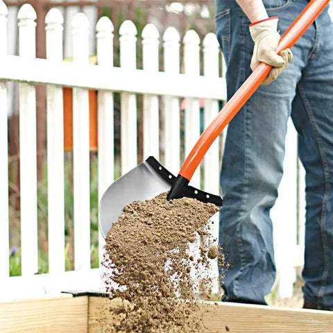 Person using Heavy Duty All Steel Round Point Shovel With 48 Inch Tubular Alloy Handle One Piece Welded Construction Thick 12 Gauge Blade 8.75 By 11.75 Inches Built For Tough Yard Work And Digging Tasks, moving soil over wooden edge.