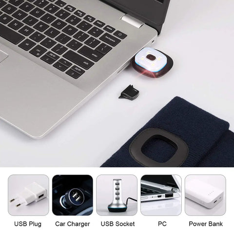 Hands Free LED Beanie With USB Rechargeable Headlamp for Kids charging via laptop, navy blue hat nearby.