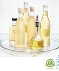 14.5 Inch Lazy Susan Organizer Set Of 2 Large Turntables For Cabinets Or Pantries With Smooth Ball Bearing Rotation And Easy Grab And Go Access, Clear See Through with bottles displayed on top.