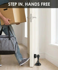 Person entering doorway with Heavy Duty Matte Black Magnetic Door Stopper 2 Pack Multi Angle Wall Guard to hold door open.