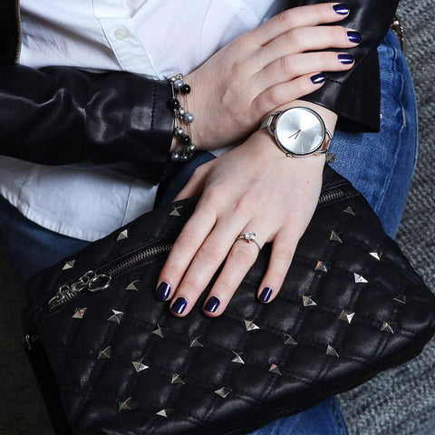 Black quilted leather handbag with silver pyramid studs; close-up view.