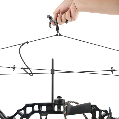 Hand holding Ultimate Game Changing Archery Bow Release For Compound Bows, Durable Aluminum Caliper Thumb Release on string.