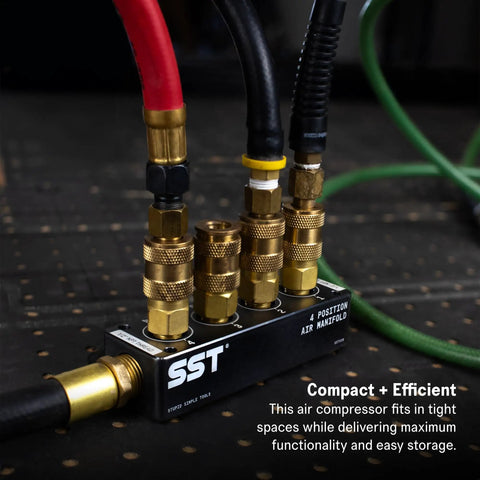 Close-up of air manifold with 1/2 NPT inlet and 1/4 NPT outlets, five positions connected to air compressor hoses in a garage setup