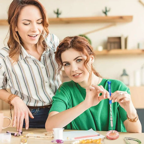 Two women engaged in crafting with the Premium 46 Piece Pin Vise Hand Drill Set With 45 Mini Twist Drill Bits Ranging From 0.3 To 3 Mm.