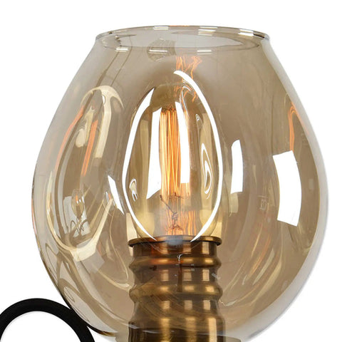 Close-up of warm amber glass shade on Six Light Industrial Chandelier Featuring Warm Amber Glass Shades And Heavy Duty Iron Frame Perfect For Upscale Cafes Bars Delivering A Chill Retro Vibe Plus Badass Vintage Charm For Your Spot.
