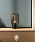 Stylish bedside table with a black metal lamp and a unique concealed round cabinet knob in matte brass.