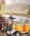 Haoweih 4 Passenger Electric Golf Cart For Adults And Seniors, 20 Mile Range, 440 Lb Capacity, Low Speed Lsv For Neighborhood, Retirement Community, And Golf Course With 650W Ac Motor And Led Display, parked by a lakeside with two adults.
