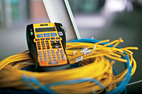 RhinoPRO 5200 Heavy Duty Label Maker With Carry Case for job sites resting on coiled network cables. Fast printing.