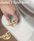 Upgrade Your Bath Setup With These Fresh Golden Bird Ceramic Toilet Bolt Caps by the toilet, showing golden bird caps being installed.