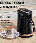 Turkish And Greek Coffee Maker For Home Use 1 To 4 Cup Capacity 400W Electric Pot BPA Free Anti Spill Design With Cook Sense Technology Delivers Authentic Foamy Brew Black displayed on countertop with cup of coffee.