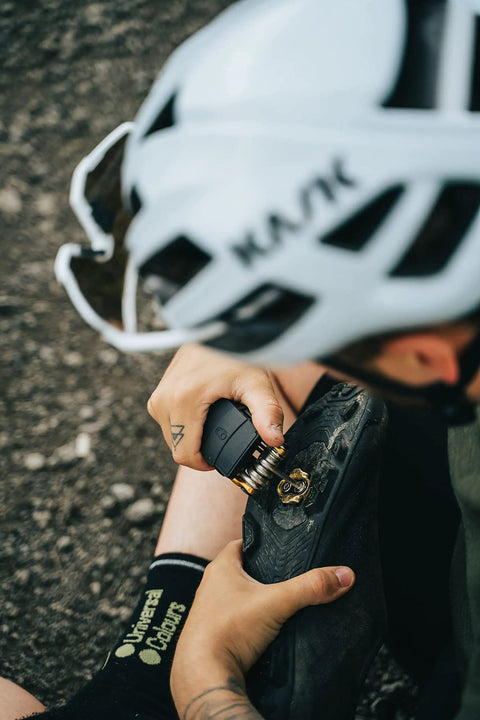 Cyclist using All In One 17 Function Bike Multi Tool Matte Black Red Hex Wrenches on a bike pedal outdoors.