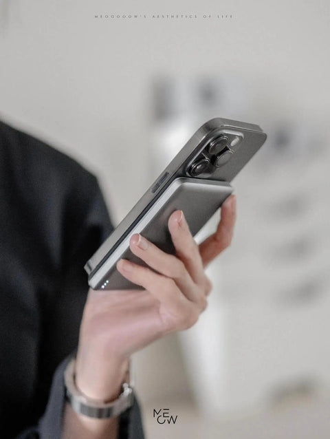 Person holding a Straight Up Top Shelf MagSafe Power Bank with iPhone, featuring slim design and secure magnetic snap.