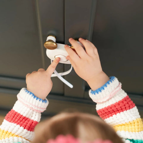 OutSmart Flex Lock Childproof Cabinet Locks White 2 Pack With Decoy Button And Flexible Design No Drill Install Fits Cabinets From 3 To 8 Inches Apart On Knobs Or Handle Pulls Easy To Install And Keep Curious Toddlers Safe