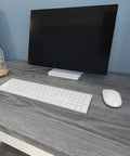 Desk with gray wood grain contact paper 24x200 self adhesive peel and stick for cabinets, featuring a computer setup.