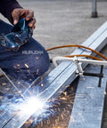 Beefy 12-Inch Heavy-Duty F-Clamps Set for Welding and Metalworking securing metal, sparks flying, all-steel construction visible.