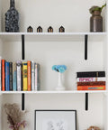 12 Pack Matte Black Heavy Duty Shelf Brackets With Screws Built Like A Tank For Rustic Home And Garage Shelving holding books and decor.
