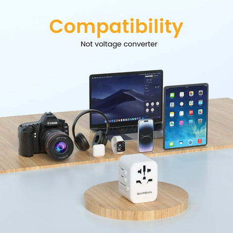 Universal Travel Plug Adapter With 4 USB Ports And Wall Charger, Worldwide Power Converter for various devices on wooden table