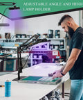 Man using 50W LED UV Screen Printing Exposure Unit with Retractable Adjustable Stand for fast emulsion curing in workshop.
