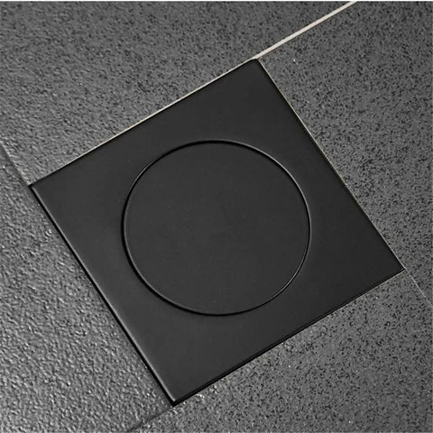 Drop Down Square Pop Up Floor Drain With Matte Black Chrome Cap and Odor Locking Grille For Bathrooms installed in floor, flush with tiles.