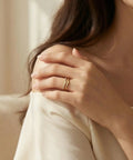 Woman wearing stackable pinky ring for women stainless steel solitaire band in gold, non tarnish wedding ring comfortable fit size 3 through 12