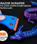 Blue scraper cleaning a purple 3D dragon model with replaceable blades, part of Must-Have 53 Piece 3D Printer Tool Kit With Nozzle Cleaning Needles.