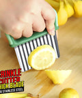 Green-handled stainless steel crinkle cutter set, two-piece, with wavy blades cutting a lemon on a wooden board.