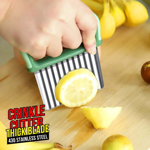 Green-handled stainless steel crinkle cutter set, two-piece, with wavy blades cutting a lemon on a wooden board.