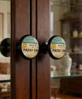 Relax And Unwind Patio Sign Cabinet Knobs 4 Pack Acrylic Round Drawer Pulls For Dresser Cupboard And Doors You're On Patio Time Vibe Hardware That Adds Chill And Easy Pulls installed on a wooden glass cabinet in a room.