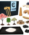 Mini Zen Garden Kit With White Sand, 10 By 7 Inch Rectangular Tray And Meditation Accessories laying out on a display table.