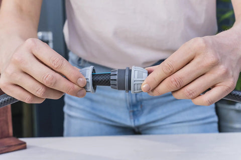 Close-up of hands using Five Eighth Inch Hose End Repair Kit for Garden Hose Fittings, Leak Repair Set With Secure Power Grip Connector.