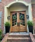 Wooden double doors with glass inserts, decorated with wreaths, suitable for Heavy Duty Double Door Lever Lock Set, Model X201110BSET.