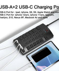 Surge Protector Power Strip With 24 Outlets And 4 USB Ports Including 2 USB C 4100J Surge Protection 6 Foot Flat Plug Heavy Duty Extension Cord ETL Listed For Home Office Dorm Room Black, angled view with tablet and charging cables