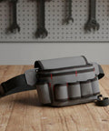 Rig Ready Waterproof Oxford Canvas Tool Belt Waist Pack With Slick Adjustable Strap And Killer Storage Loops Hella Comfortable For Electricians Crushing It On Site, gray tool belt with pockets on wooden surface.