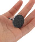 Portable Nail Care Kit With 80 150 240 Grit Sandpaper Discs For Dead Skin Removal, Foot File Sanding Sheets, Grab And Go Travel Friendly Nail And Foot Grooming Set For Home Or On The Go. single black sanding disc held in hand