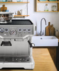 Breville espresso machine on a kitchen counter with a glass bowl of coffee beans on top