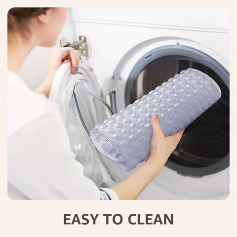 Big Time Grip Non Slip Bathtub Shower Mat features heavy duty suction cups being placed in a washing machine for easy cleaning.