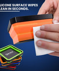 Person cleaning foldable magnetic parts tray with silicone surface; set includes color-coded collapsible trays in orange.