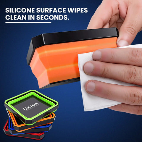 Person cleaning foldable magnetic parts tray with silicone surface; set includes color-coded collapsible trays in orange.